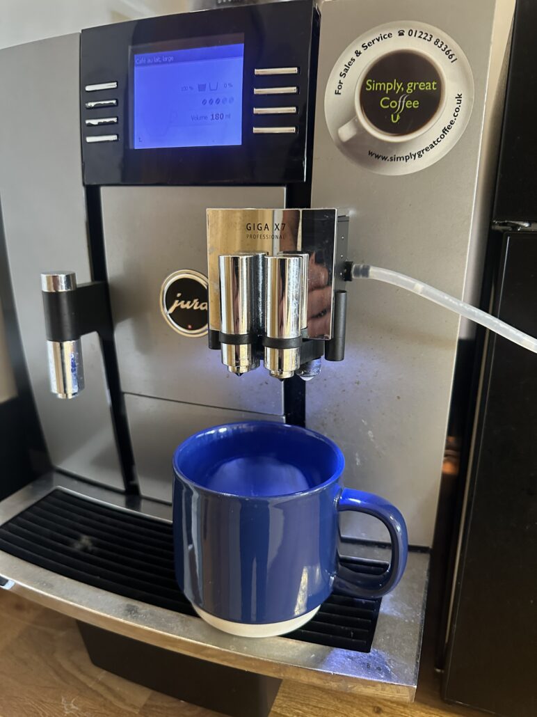 A Jura Giga X7 Professional coffee machine brewing into a blue mug at Ely Work Collective